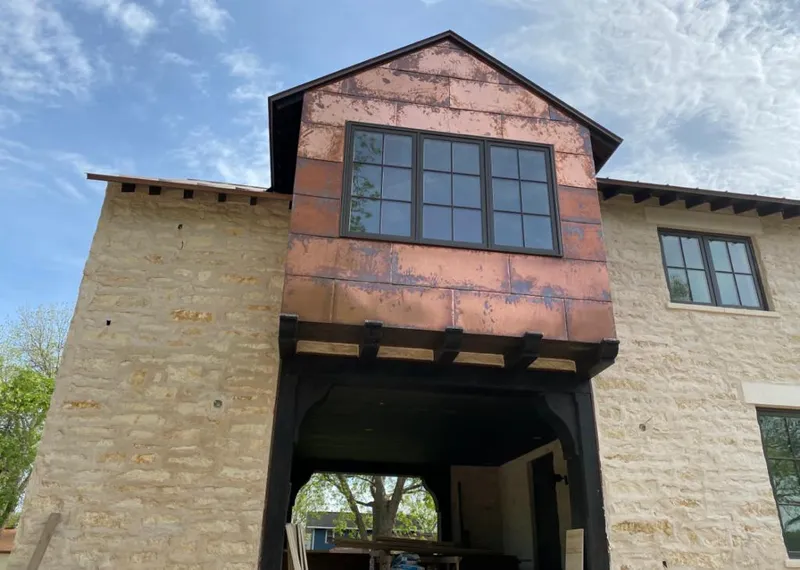 Copper metal panel facade on a stone building for Skylight Installation in Hammond